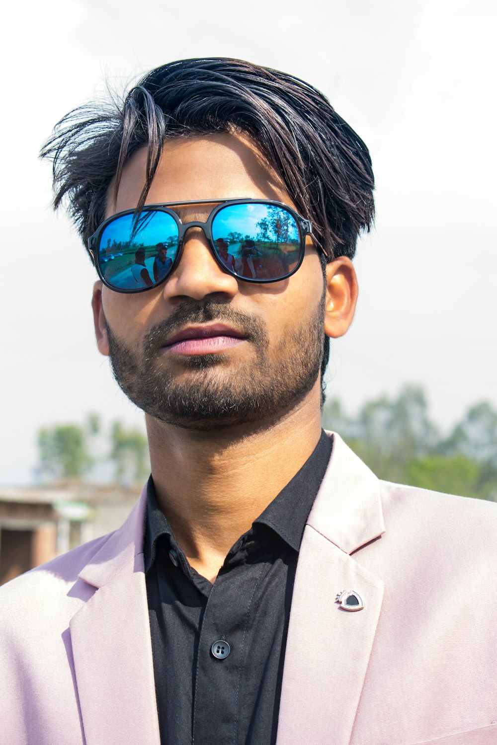 a man in a pink suit and blue sunglasses
