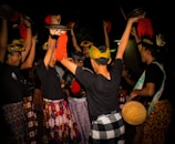 a group of people standing around each other holding hats