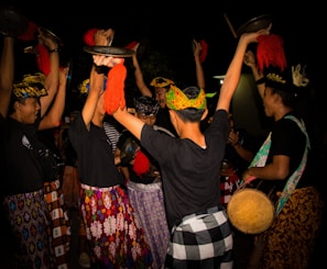 a group of people standing around each other holding hats