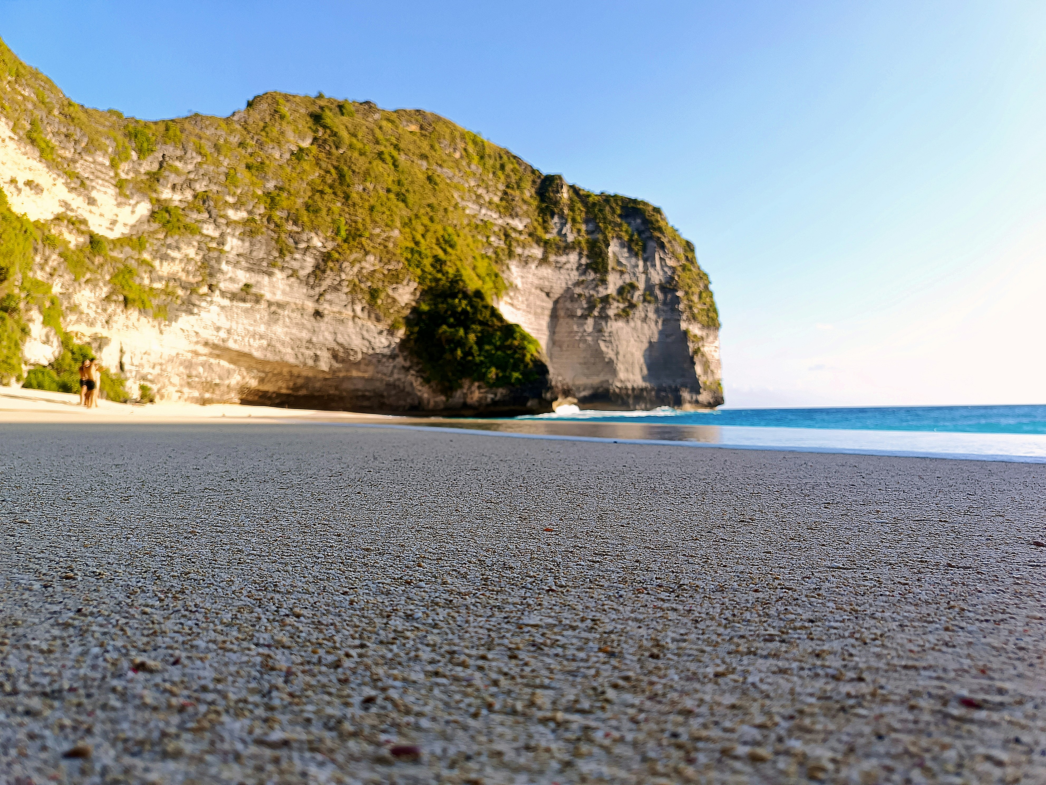 a sandy beach with a mountain in the background