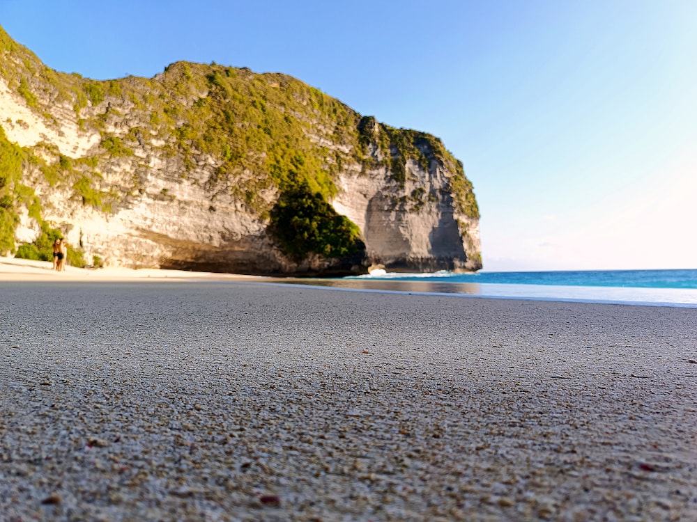 a sandy beach with a mountain in the background