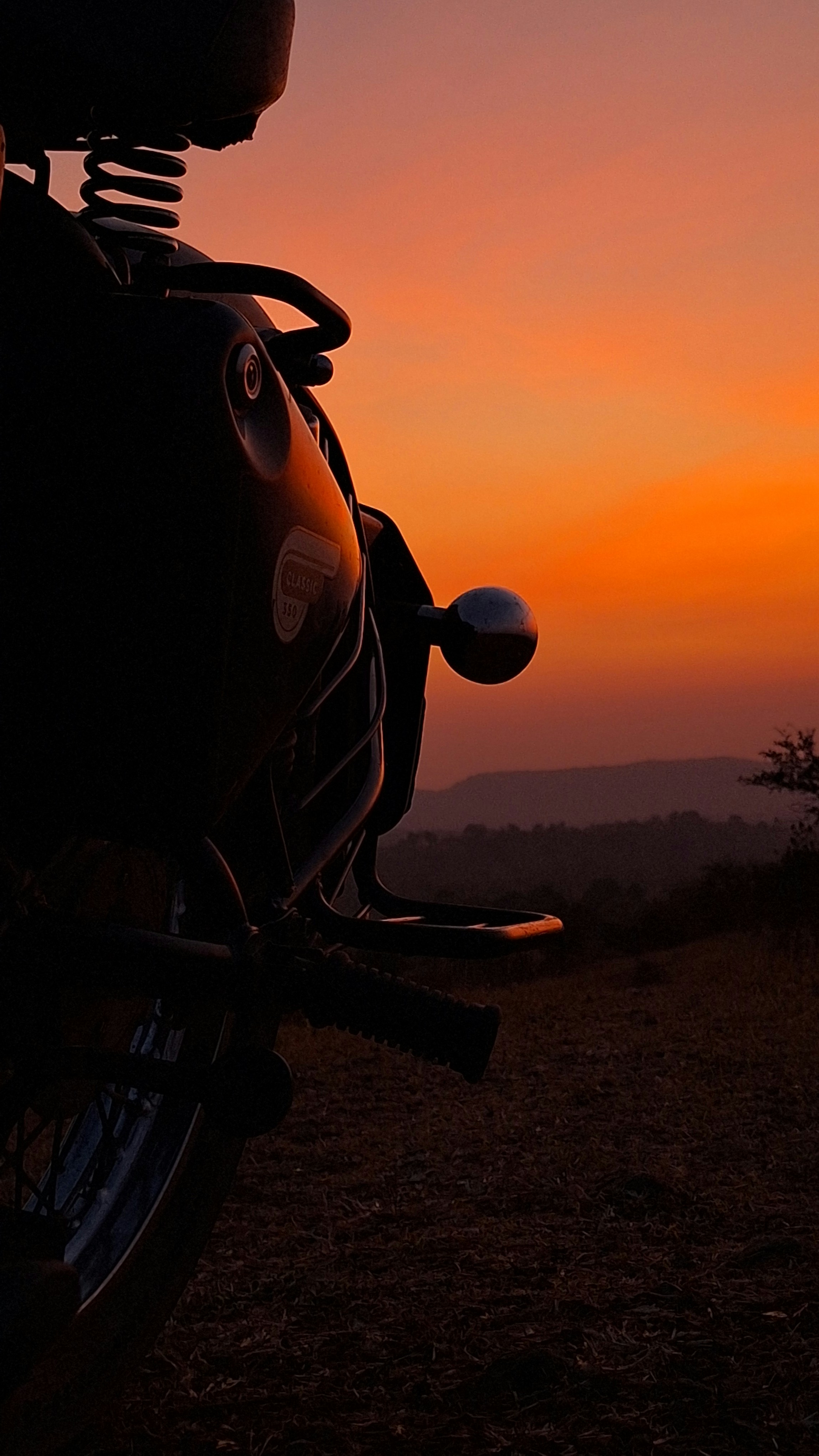 Texas sunset with silhouette of motorcycle and rider against blazing orange and purple sky, open plains