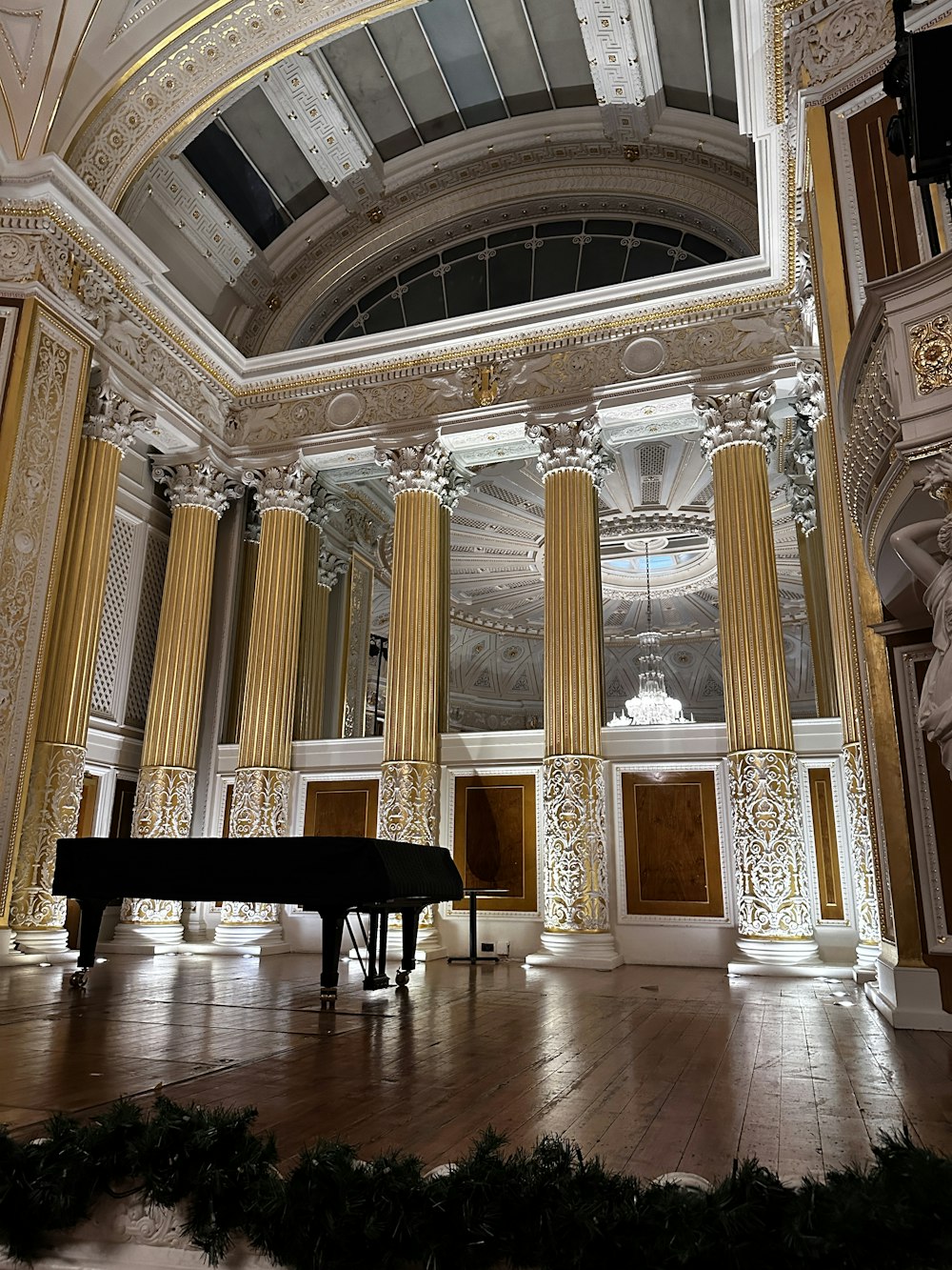 a grand piano in a large room with columns