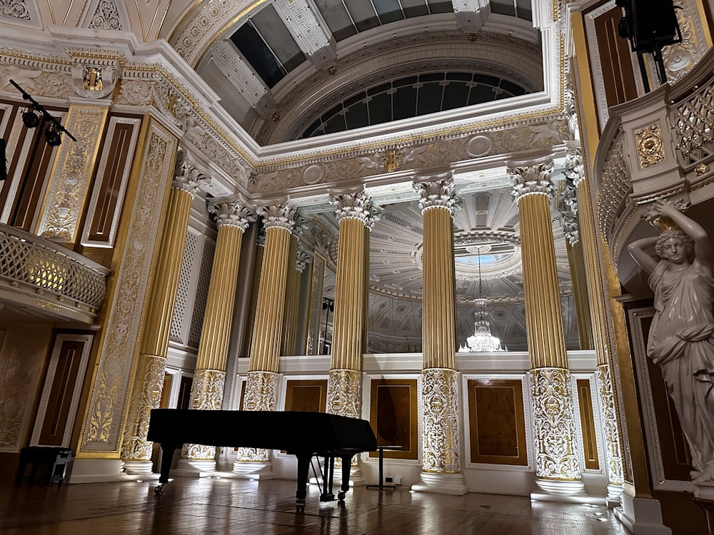a grand piano in a large room with columns