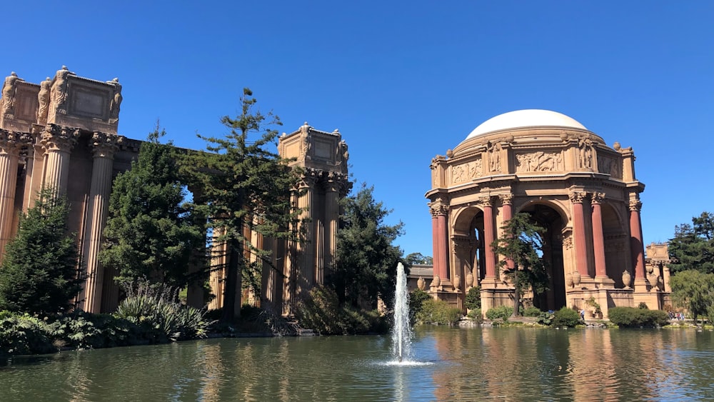 a pond with a fountain in front of a building