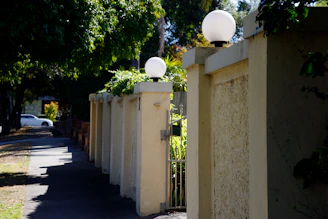 a street with a fence and two lamps on it