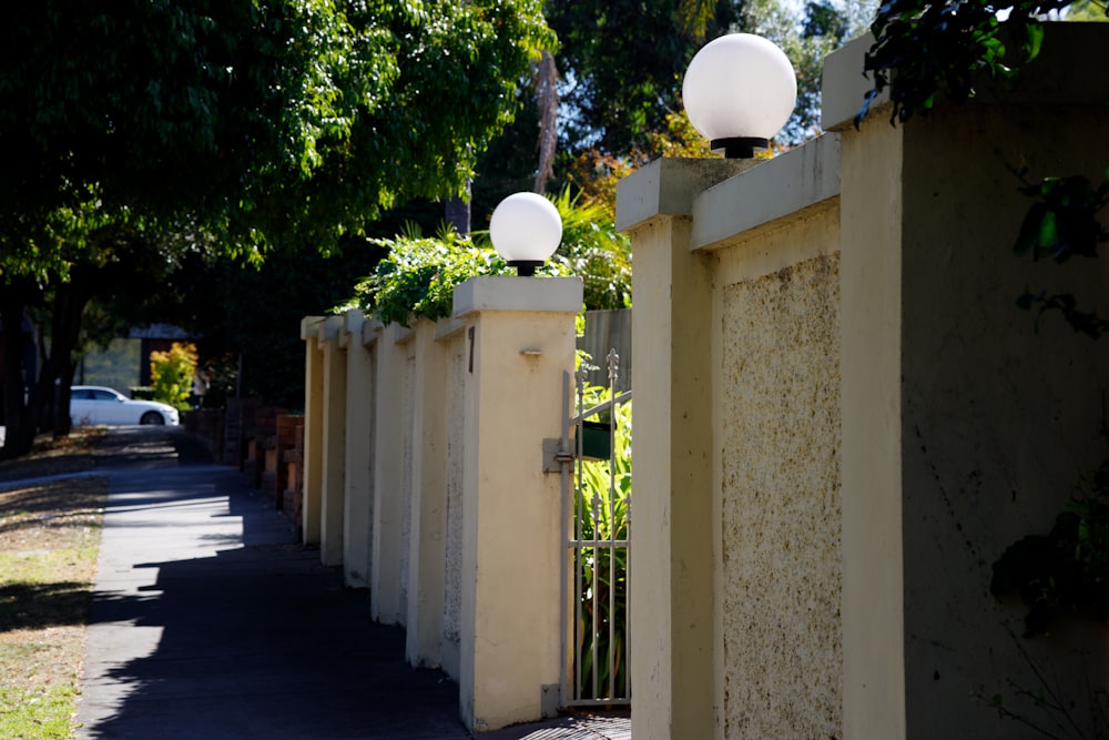 eine Straße mit einem Zaun und zwei Lampen darauf