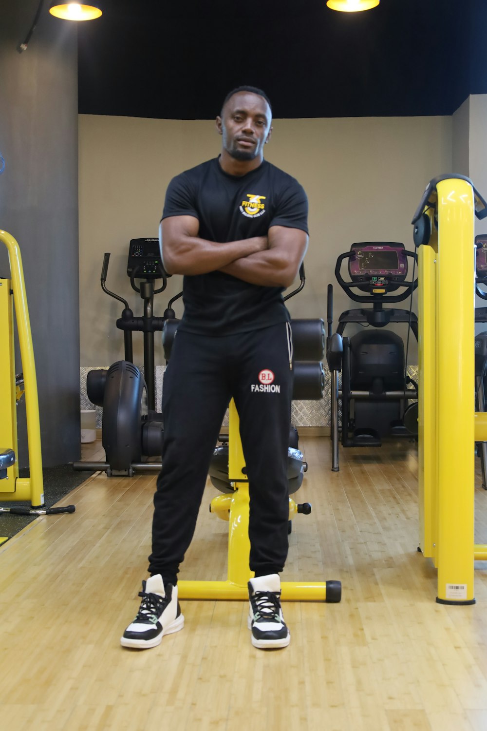 a man standing in a gym with his arms crossed