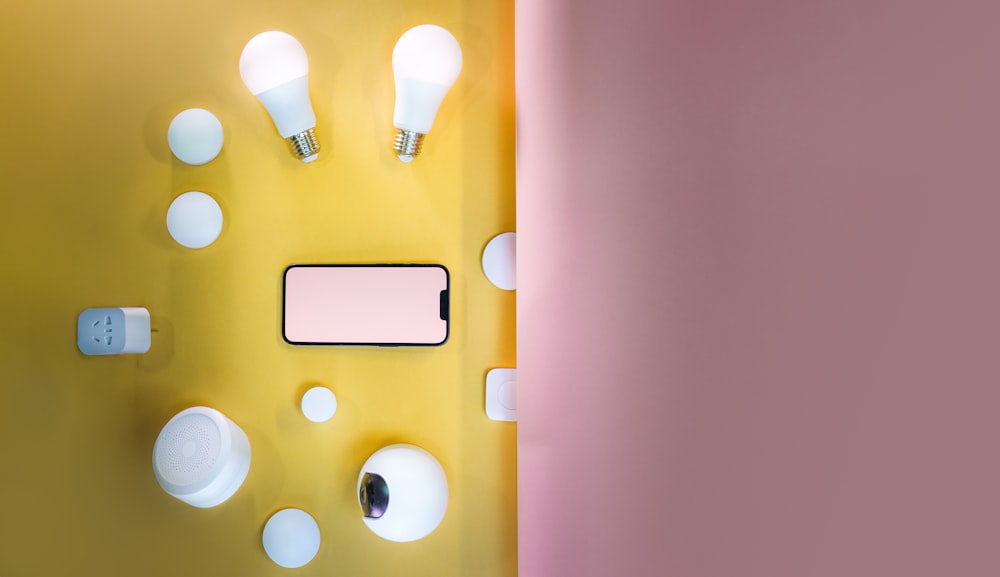 노란색과 분홍색의 벽과 그 위에 휴대폰이 놓여 있다