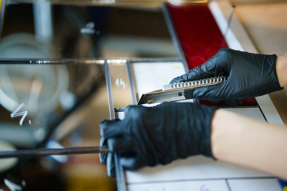 Ein Paar schwarze Handschuhe wird an einer Maschine verwendet