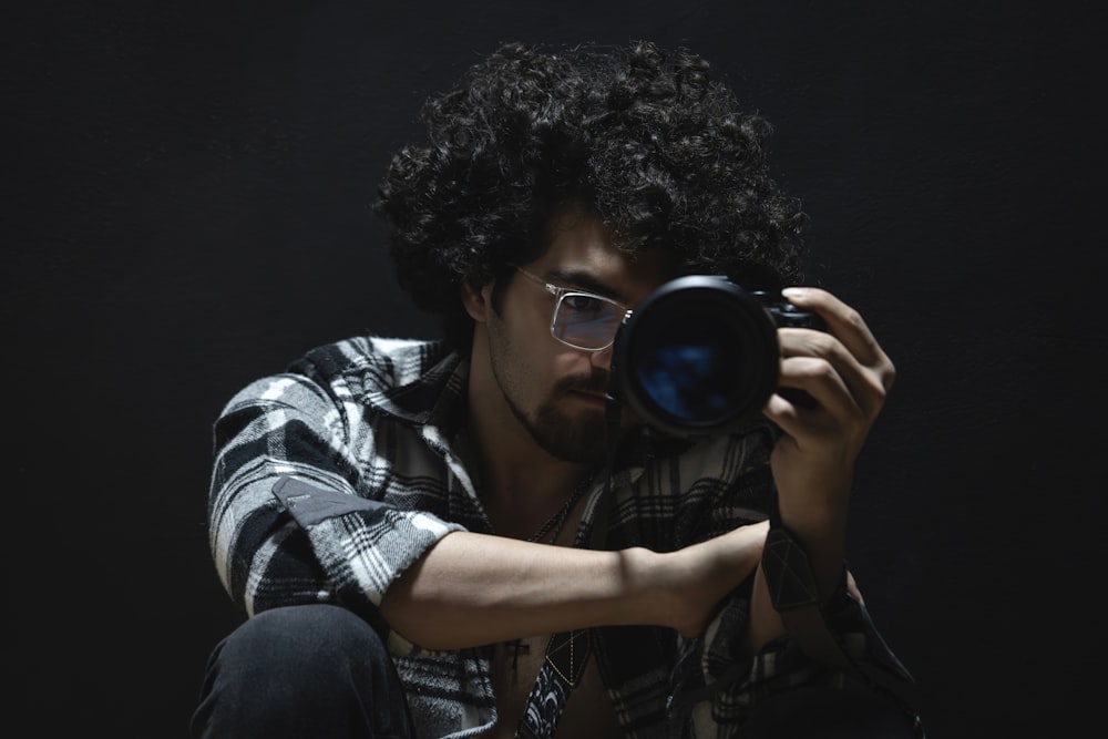 a man sitting on the ground holding a camera