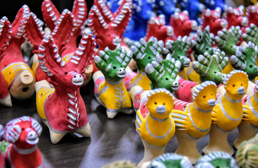 a table topped with lots of colorful ceramic animals