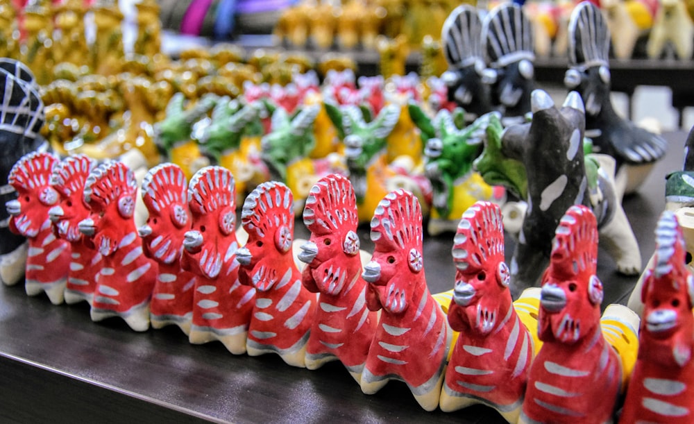 a row of red and white ceramic animals on a table