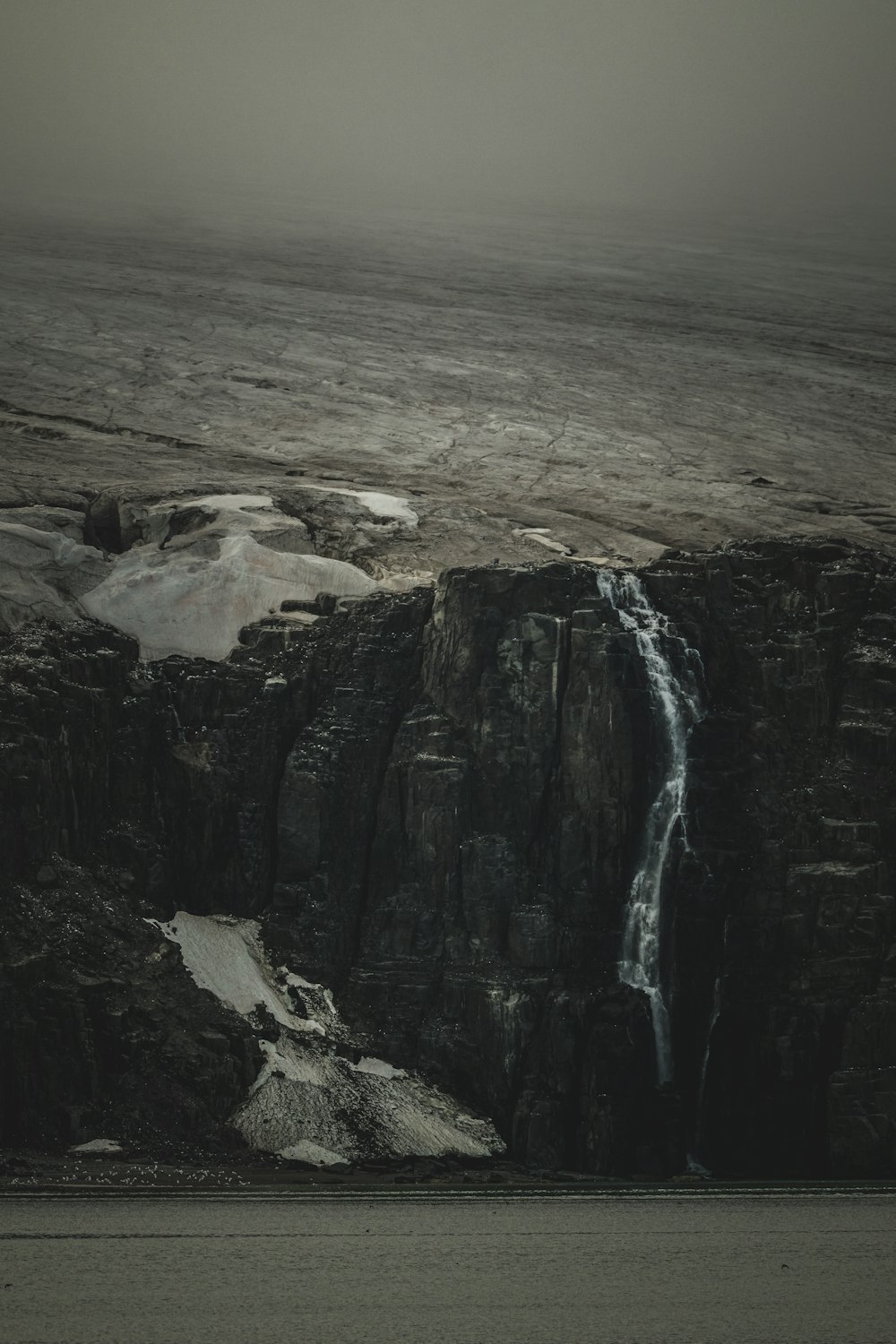 a black and white photo of a waterfall