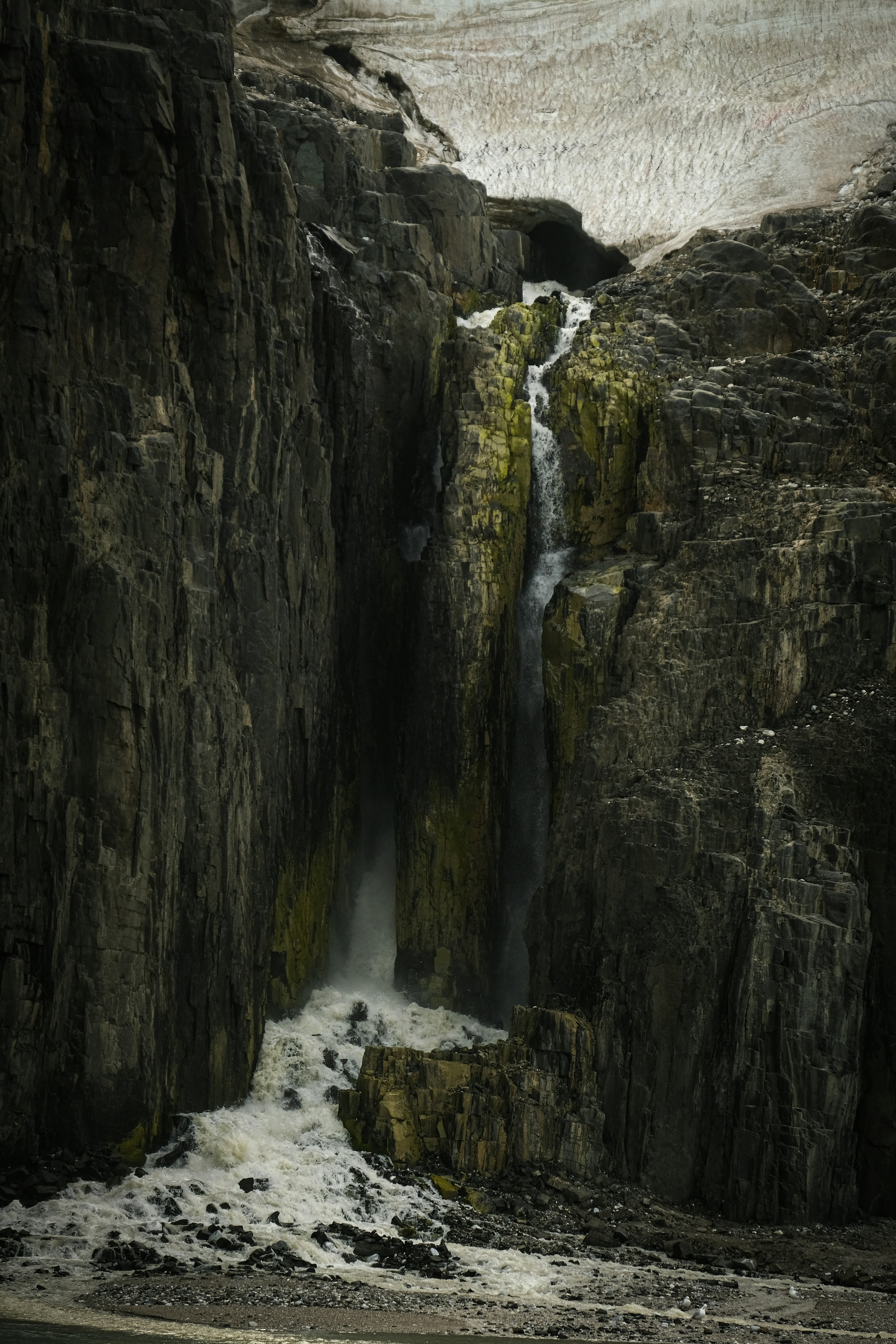 a waterfall in the middle of a rocky cliff