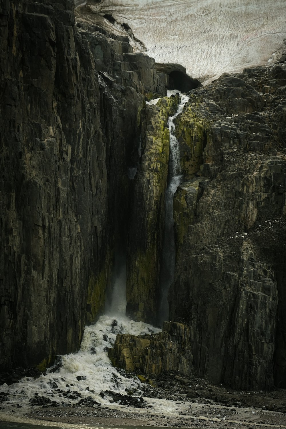 a waterfall in the middle of a rocky cliff
