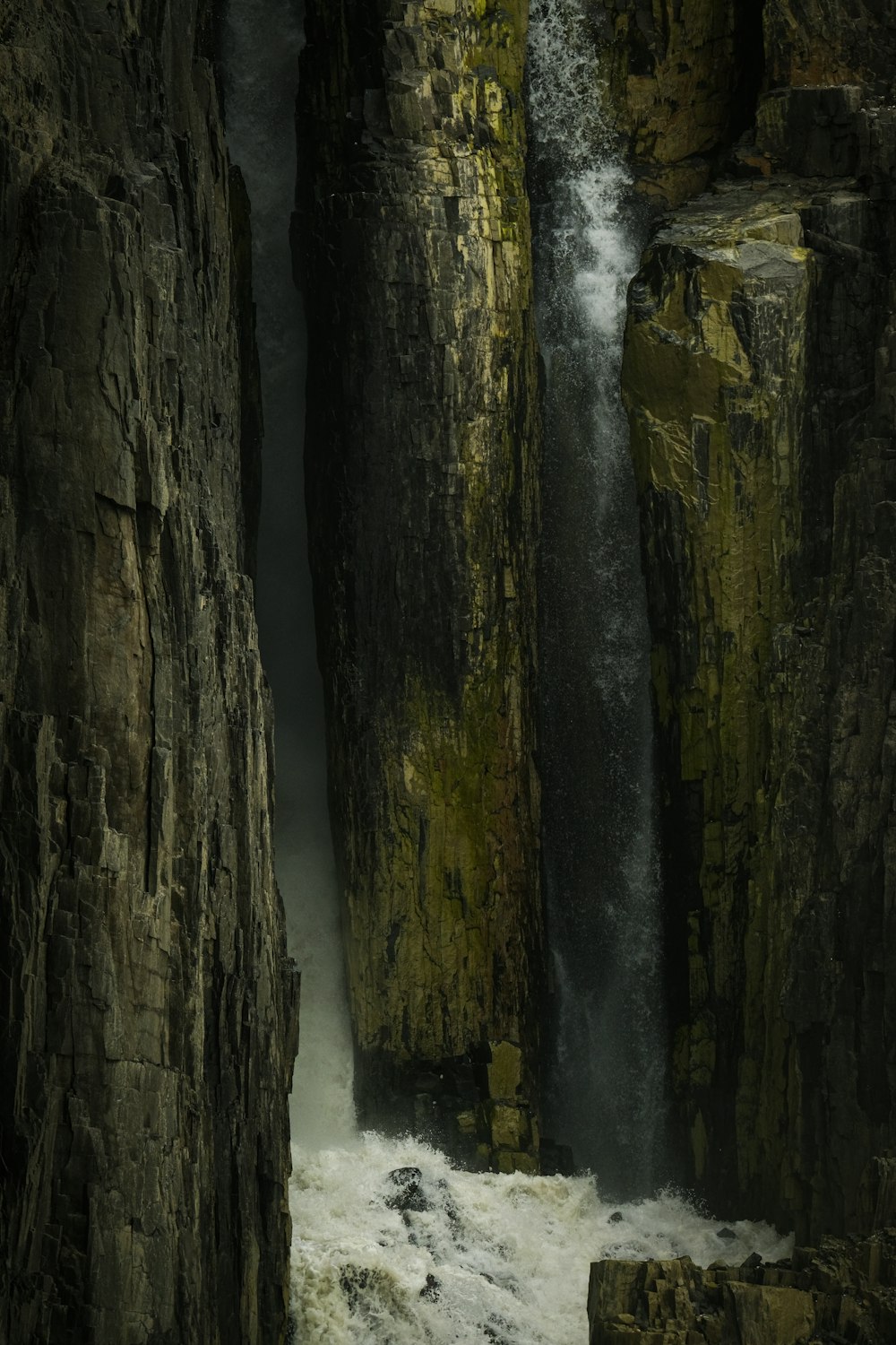 Ein Wasserfall kommt aus den Felsen ins Wasser