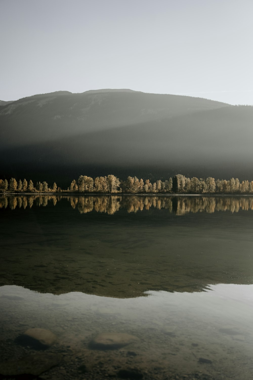 uno specchio d'acqua con una montagna sullo sfondo