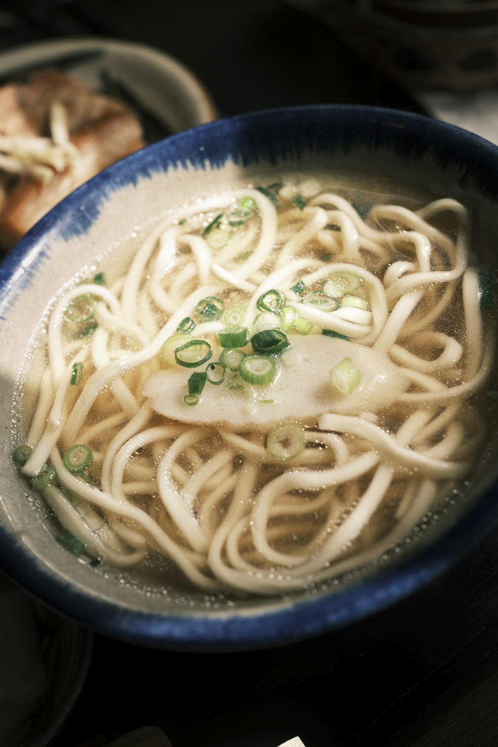 una ciotola di ramen con noodles e cipolle verdi