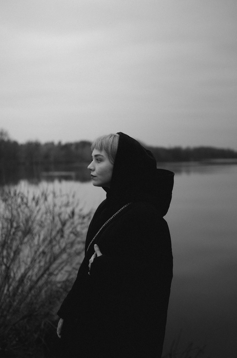 a black and white photo of a person near a body of water