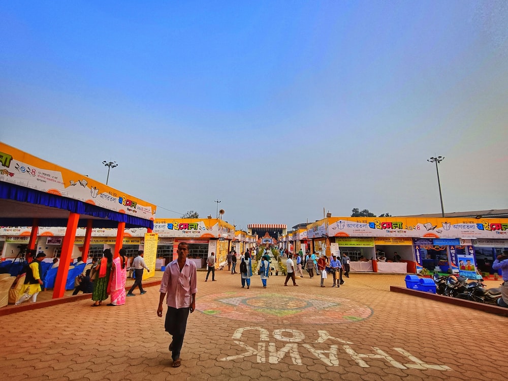 a crowd of people walking around a market