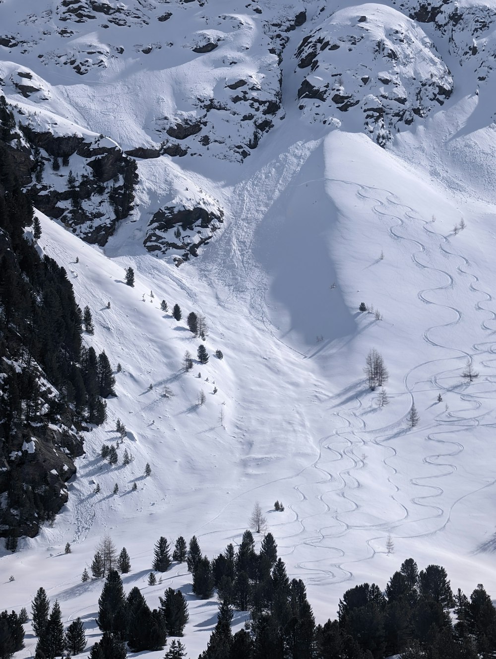 a snow covered mountain with tracks in the snow