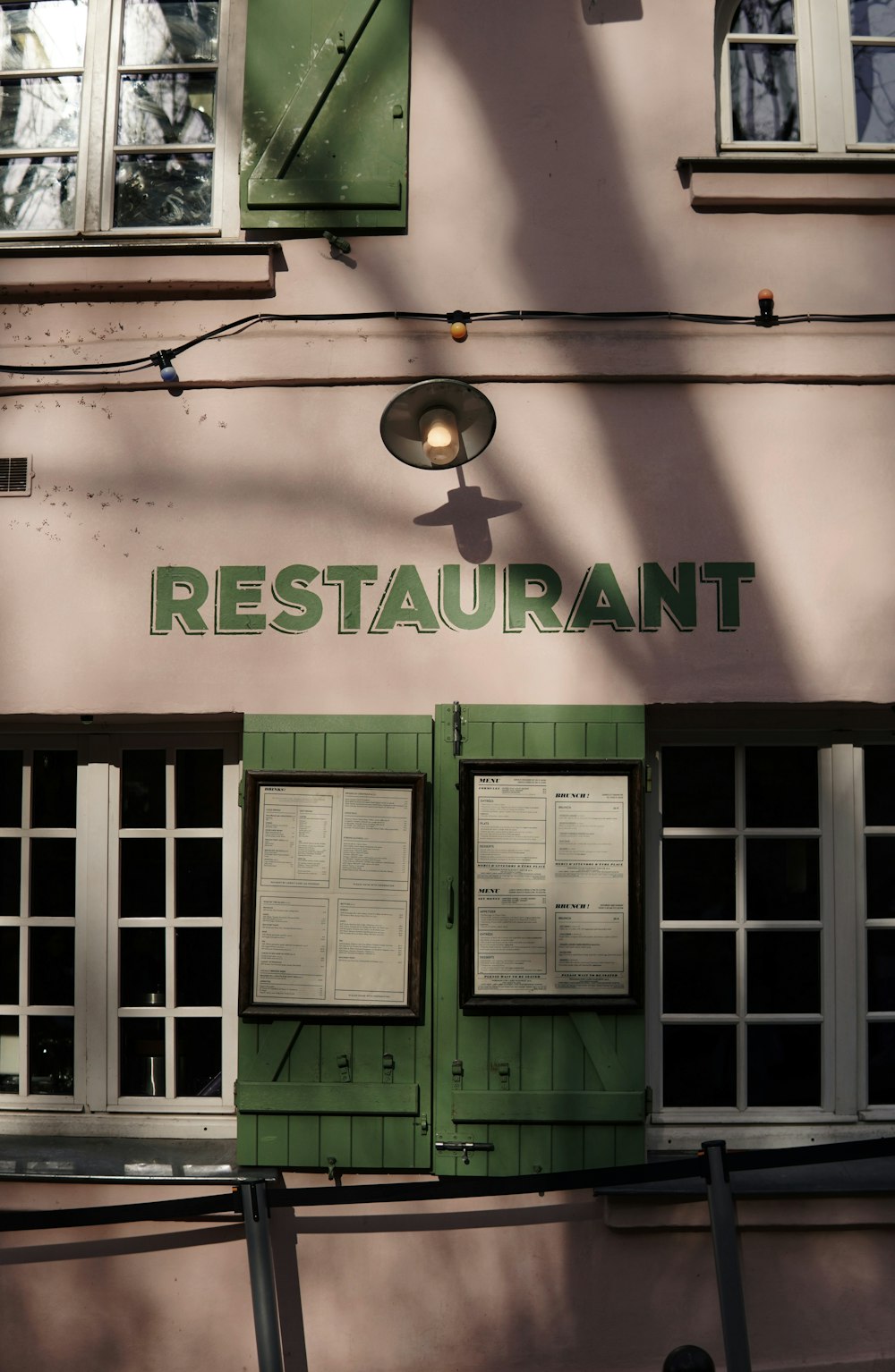a restaurant with green shutters on a building