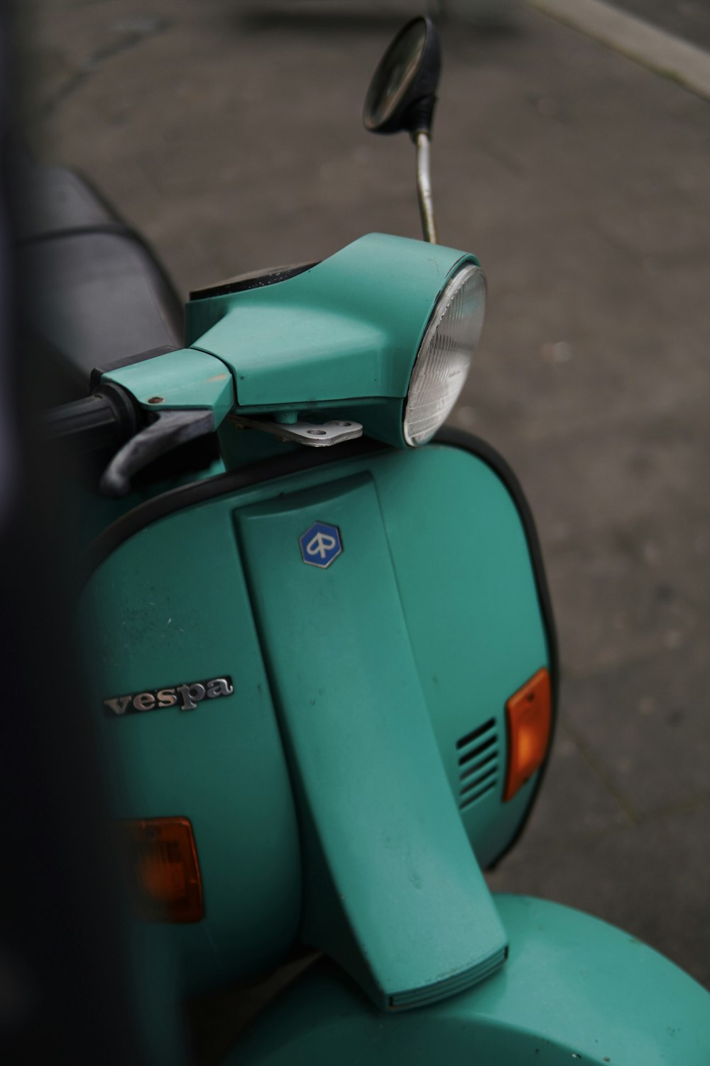 Un scooter verde estacionado al costado de la carretera