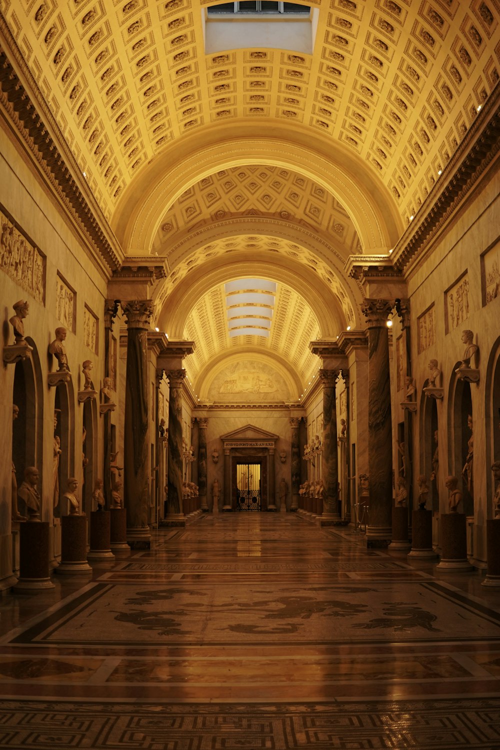 a very long hallway with statues on either side of it