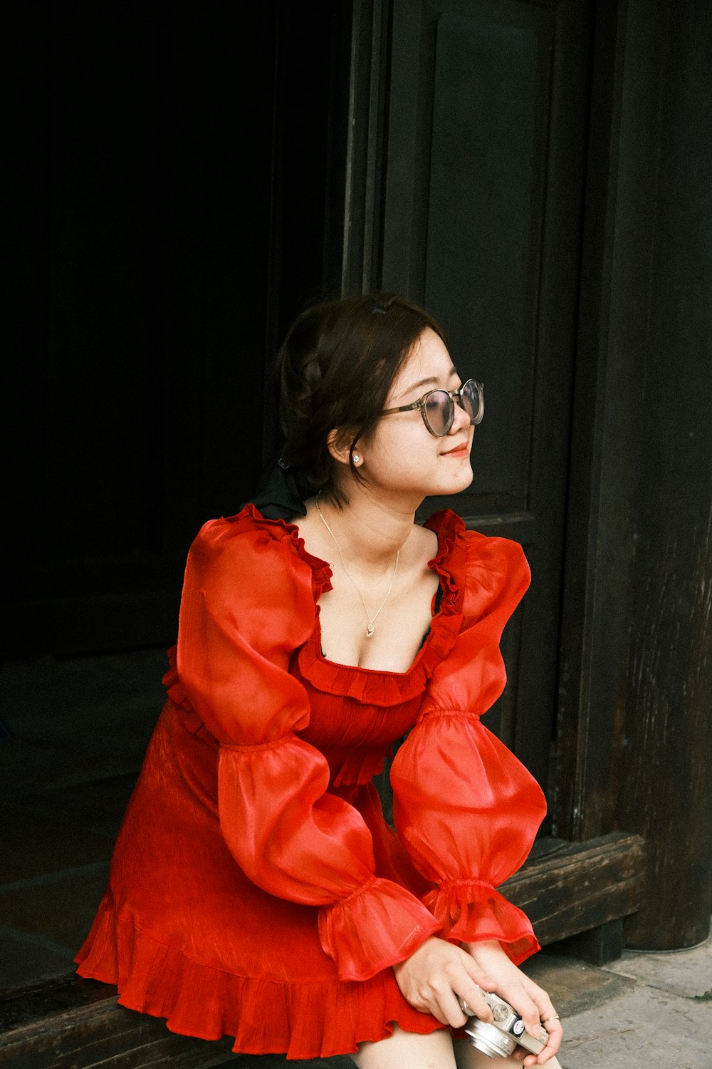 a woman in a red dress sitting on a step
