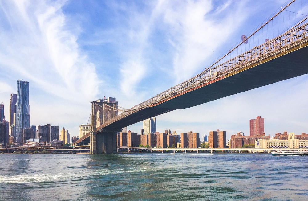 a bridge over a body of water with a city in the background