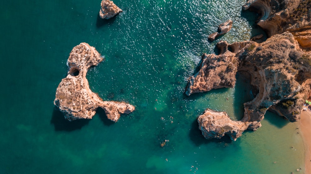 an aerial view of a beach with rocks in the water