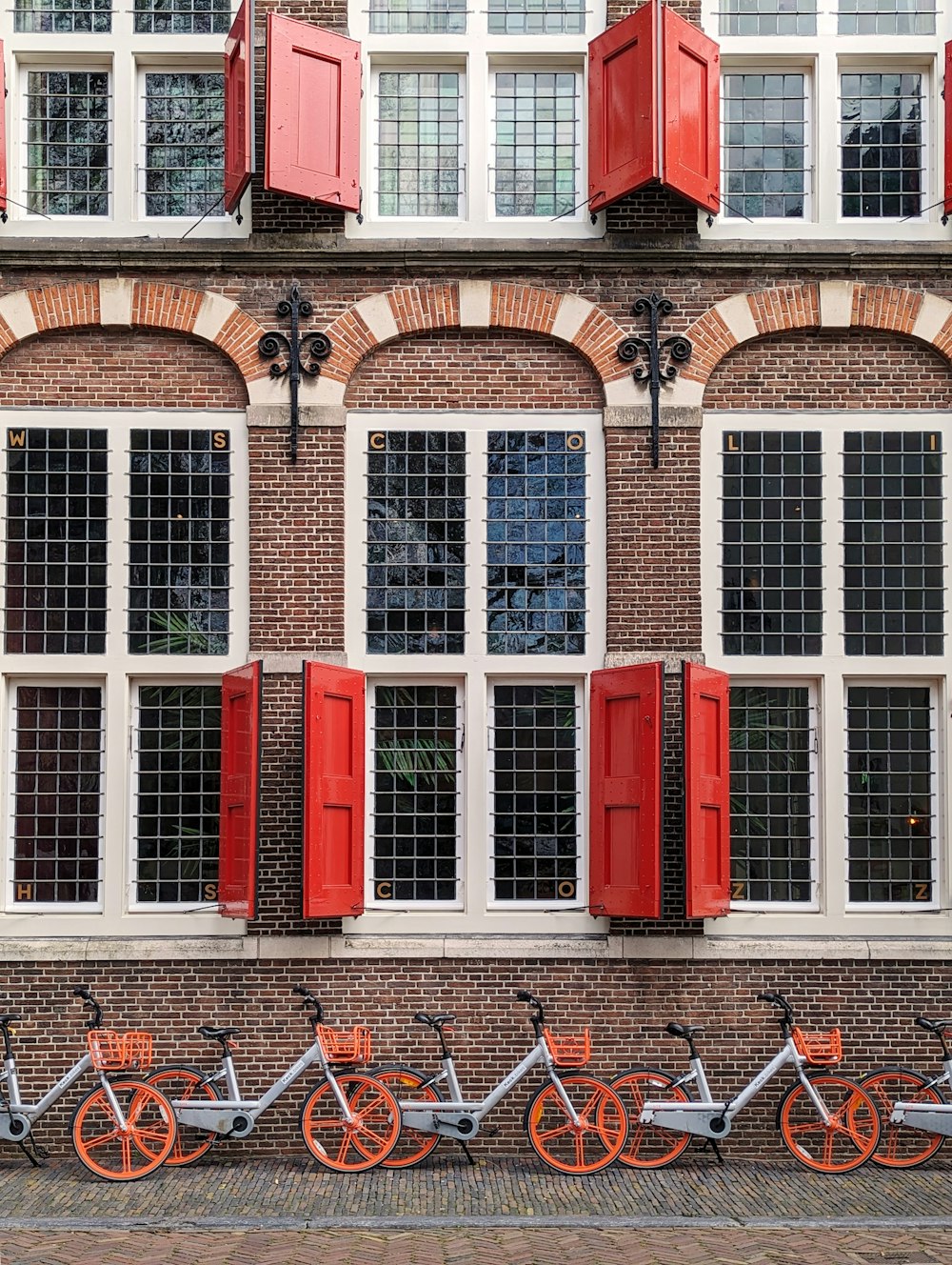 a row of bikes parked next to each other in front of a building