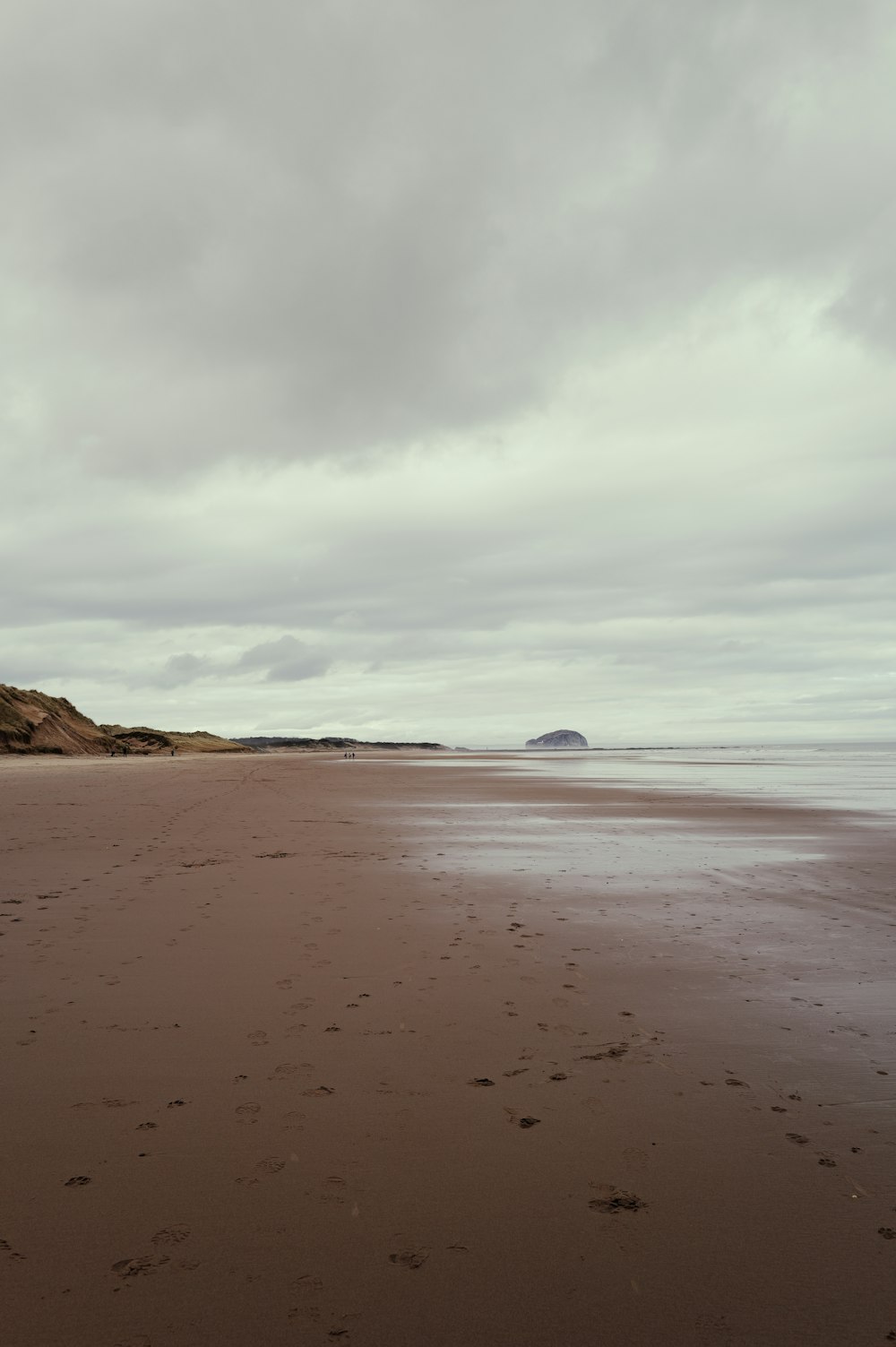 a sandy beach with footprints in the sand