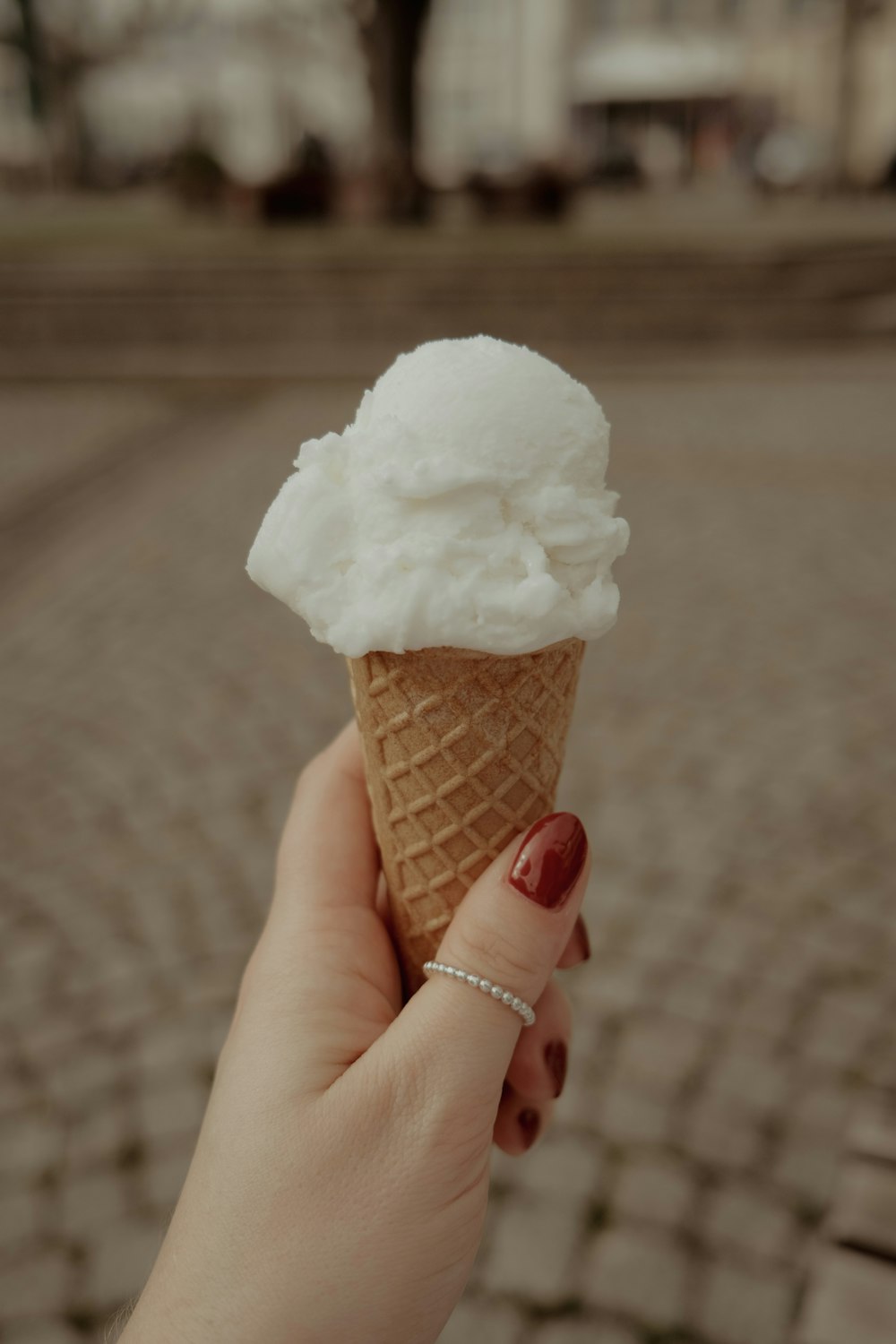 a hand holding a cone of ice cream