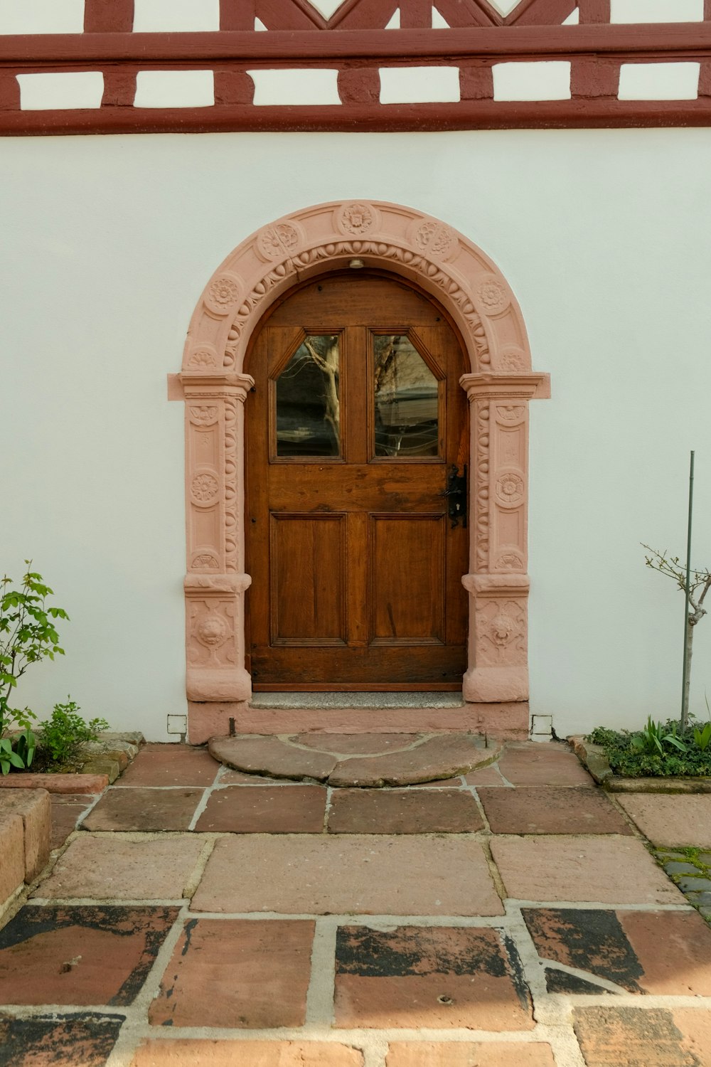 a large wooden door sitting next to a white wall