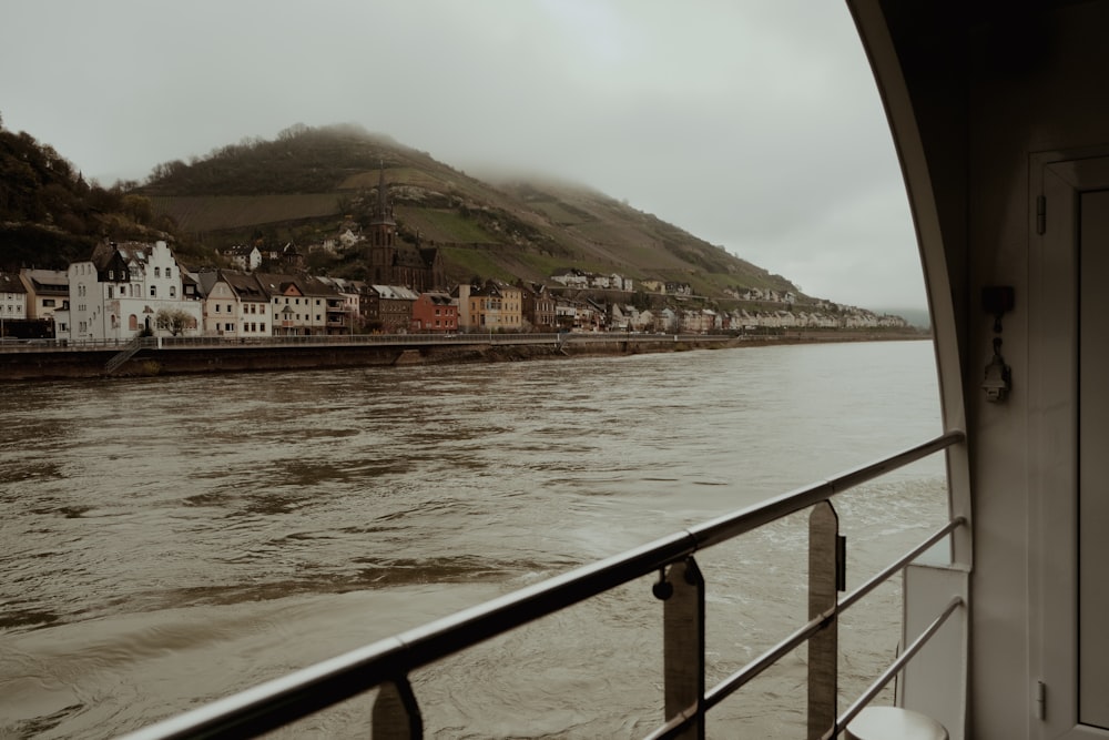 a boat traveling down a river next to a hillside