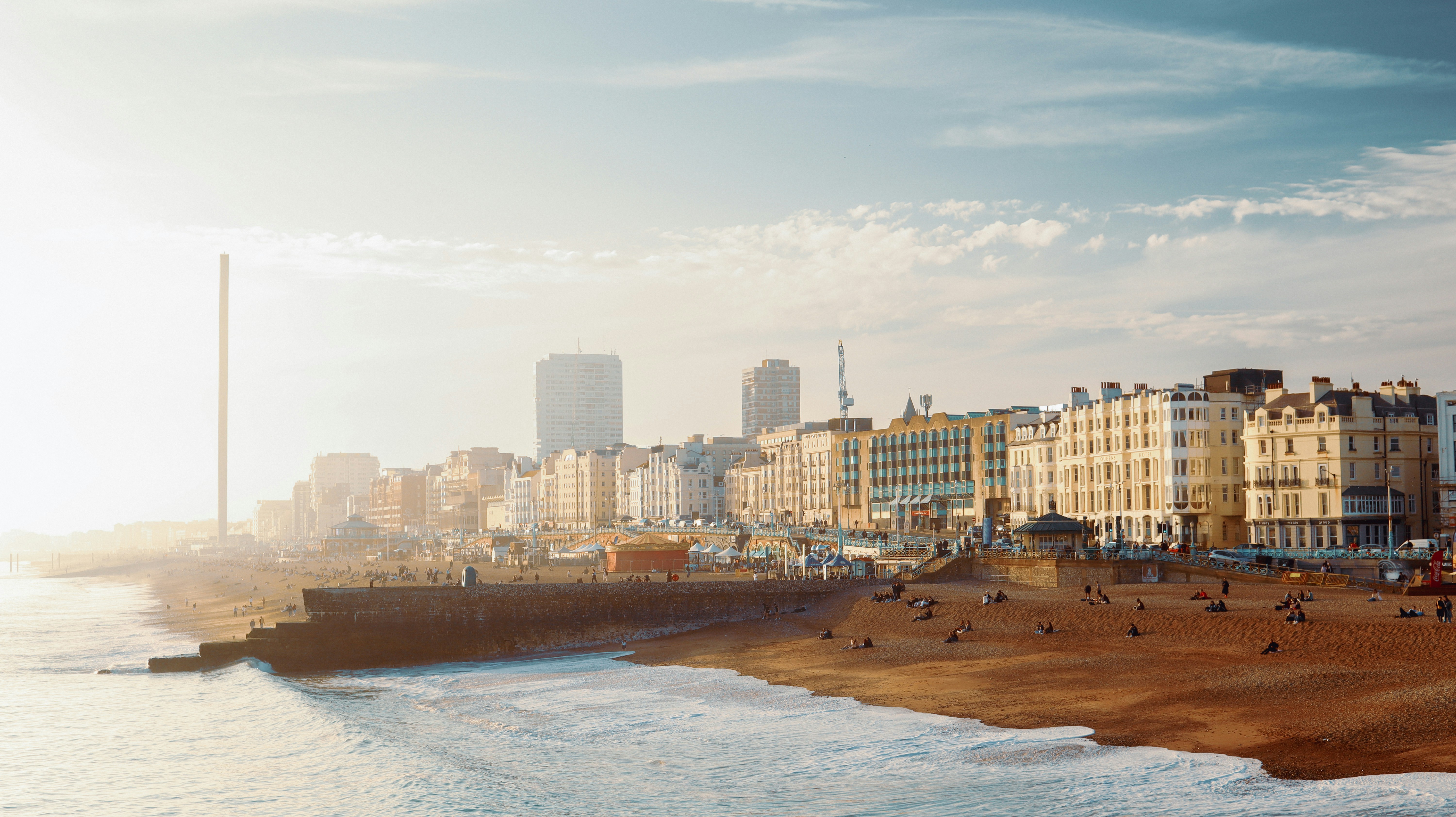 a beach next to a city with tall buildings. Brighton. Develop 2025