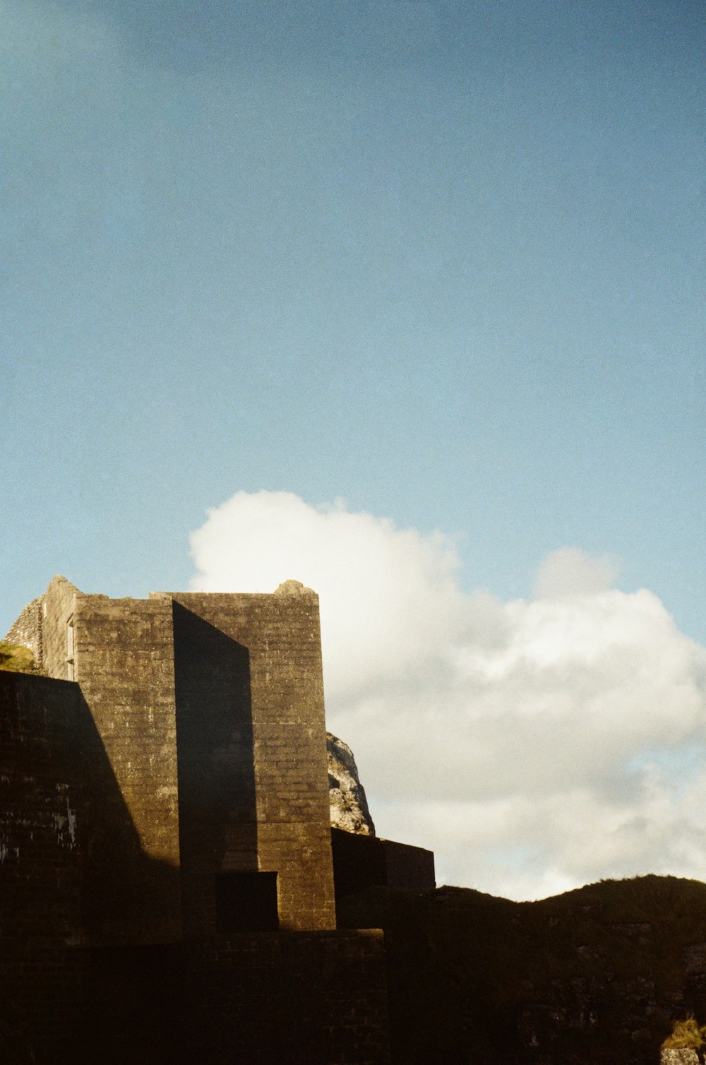 a tall building sitting on top of a lush green hillside