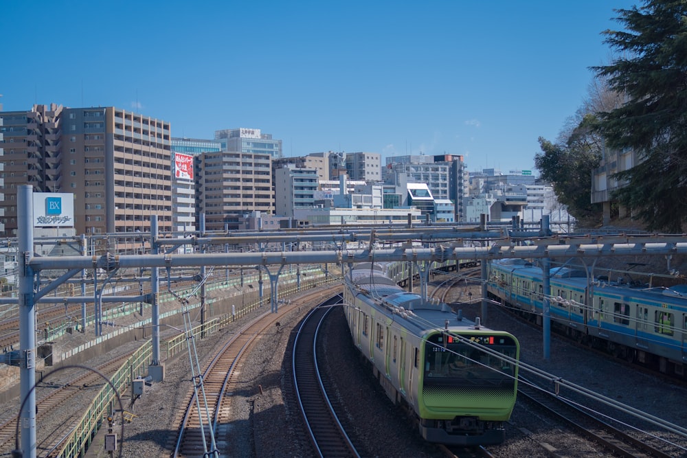 a train traveling down train tracks next to tall buildings