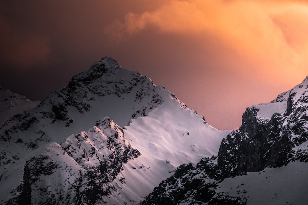 a snow covered mountain under a cloudy sky