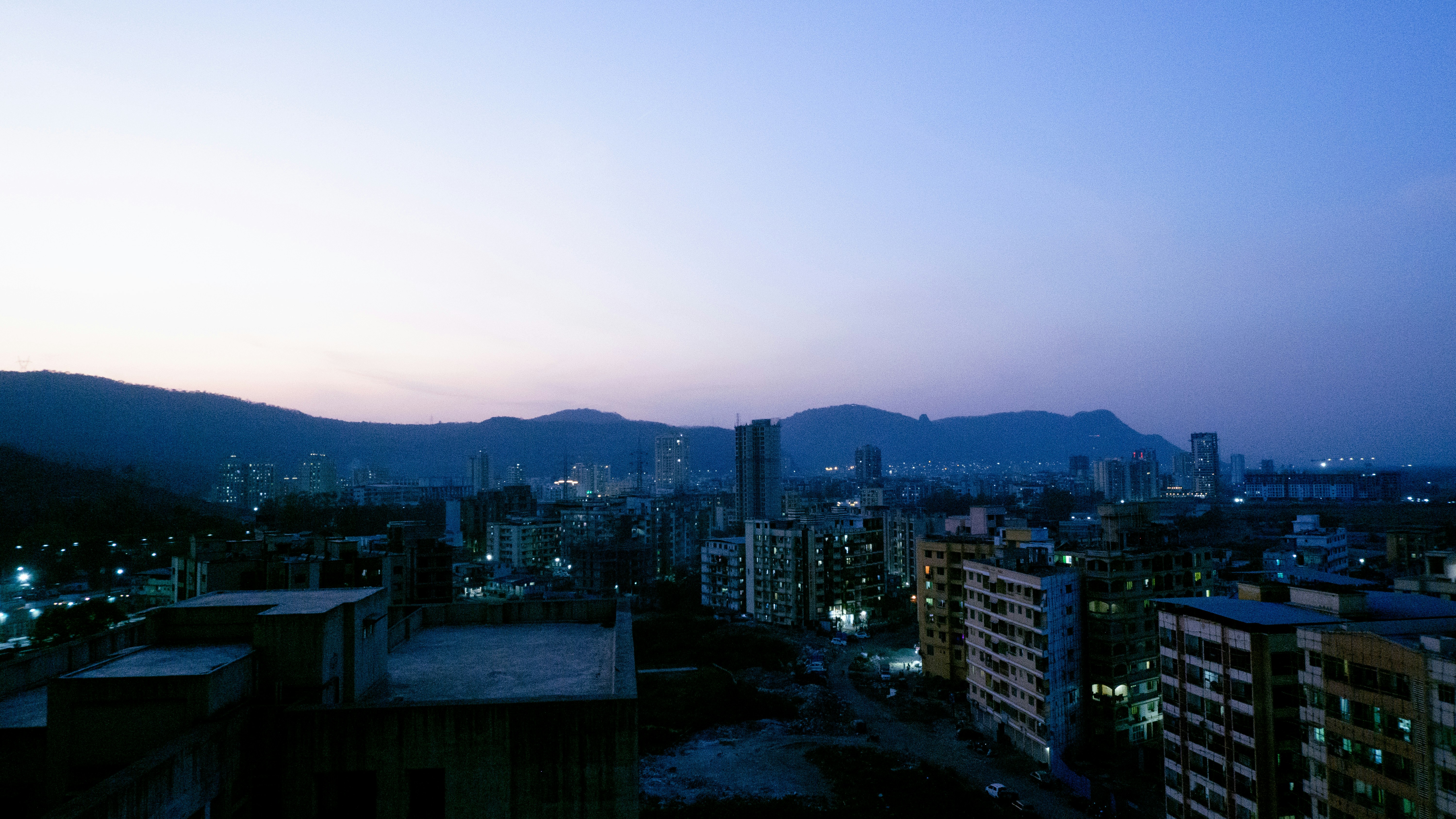 a view of a city at night with mountains in the background