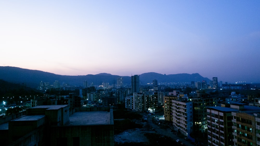 a view of a city at night with mountains in the background