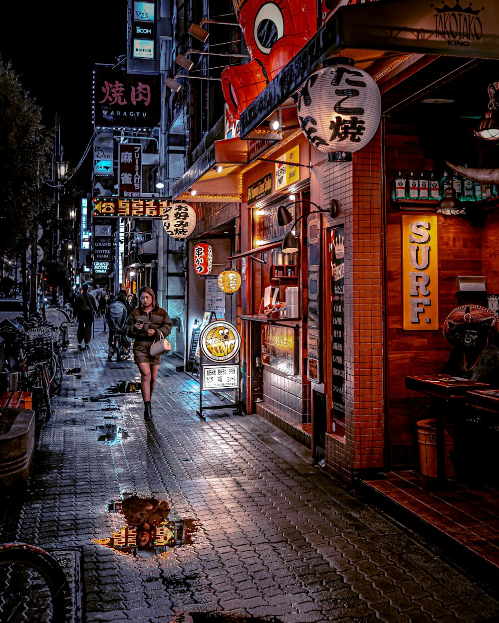 a woman walking down a street at night