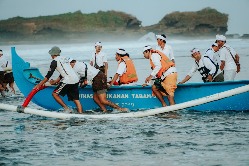 a group of people in a blue boat in the water