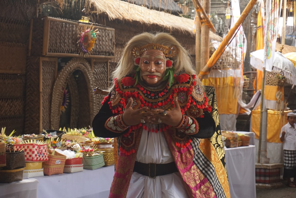 a man dressed in a costume standing in front of a table