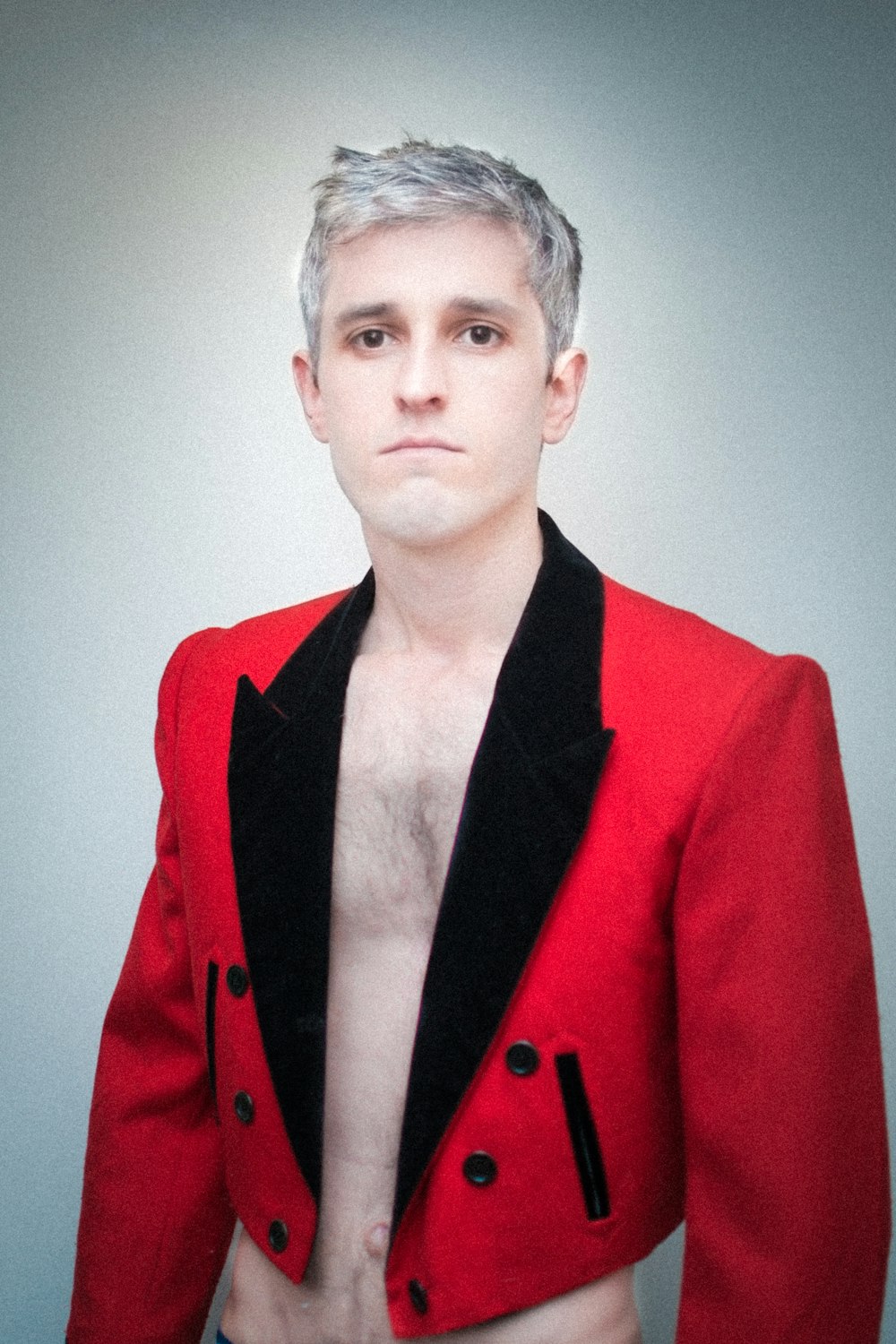 a man in a red jacket with no shirt