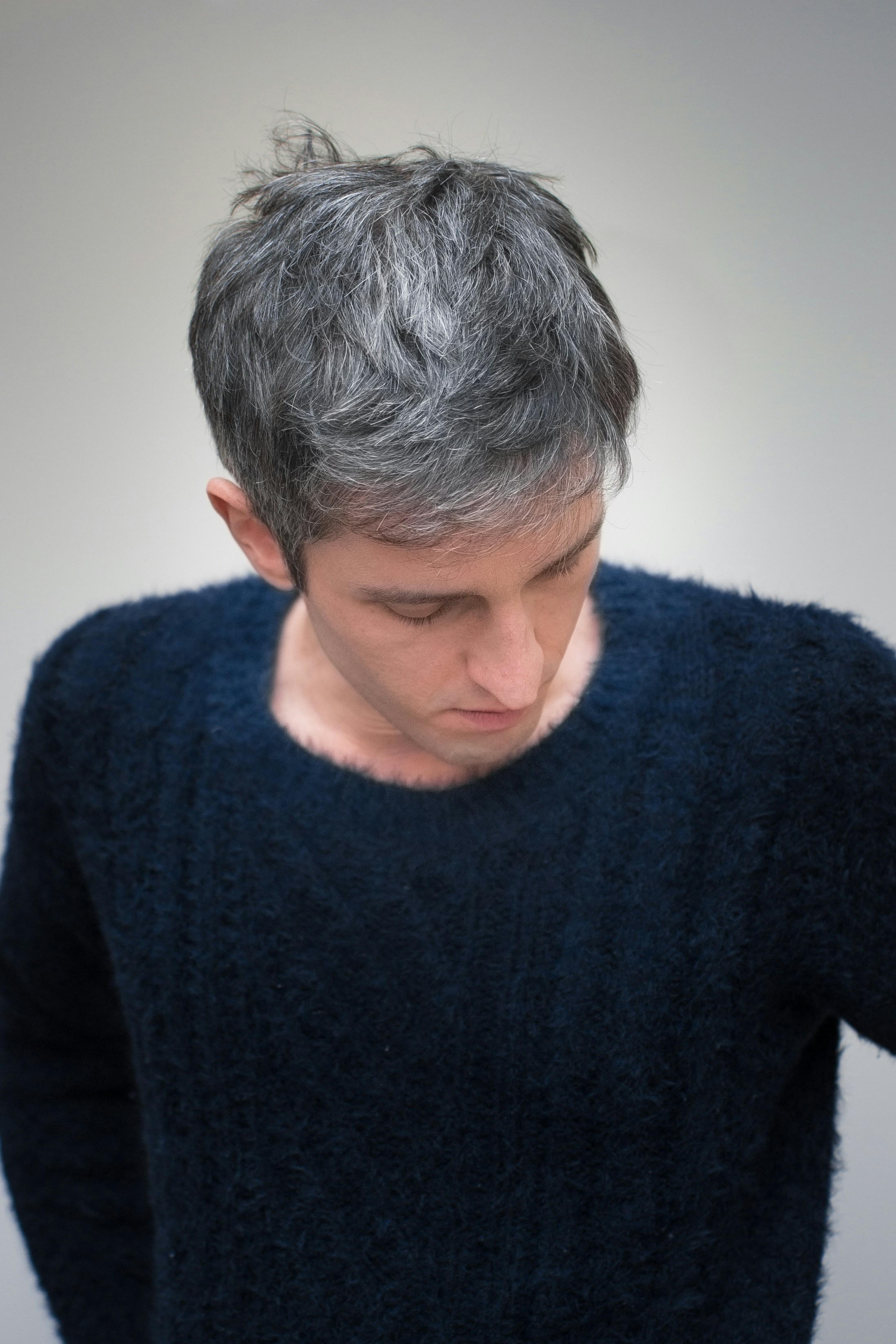 a man with grey hair is looking down