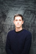 a man in a blue sweater posing for a picture