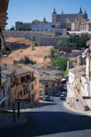 a view of a street with buildings and a hill in the background